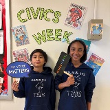 Students hold Civic Week signs.