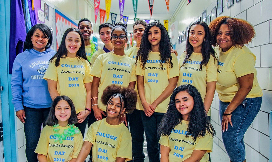 Collage Access Day Page Students gathered in a hallway in a school with yellow tee shirts that say