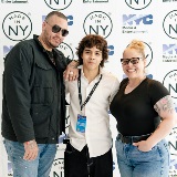 Student filmmaker poses with parents.