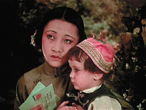 A still image from the 1922 silent film 'Toll of the Sea,' depicting Anna May Wong in a scene with young child.