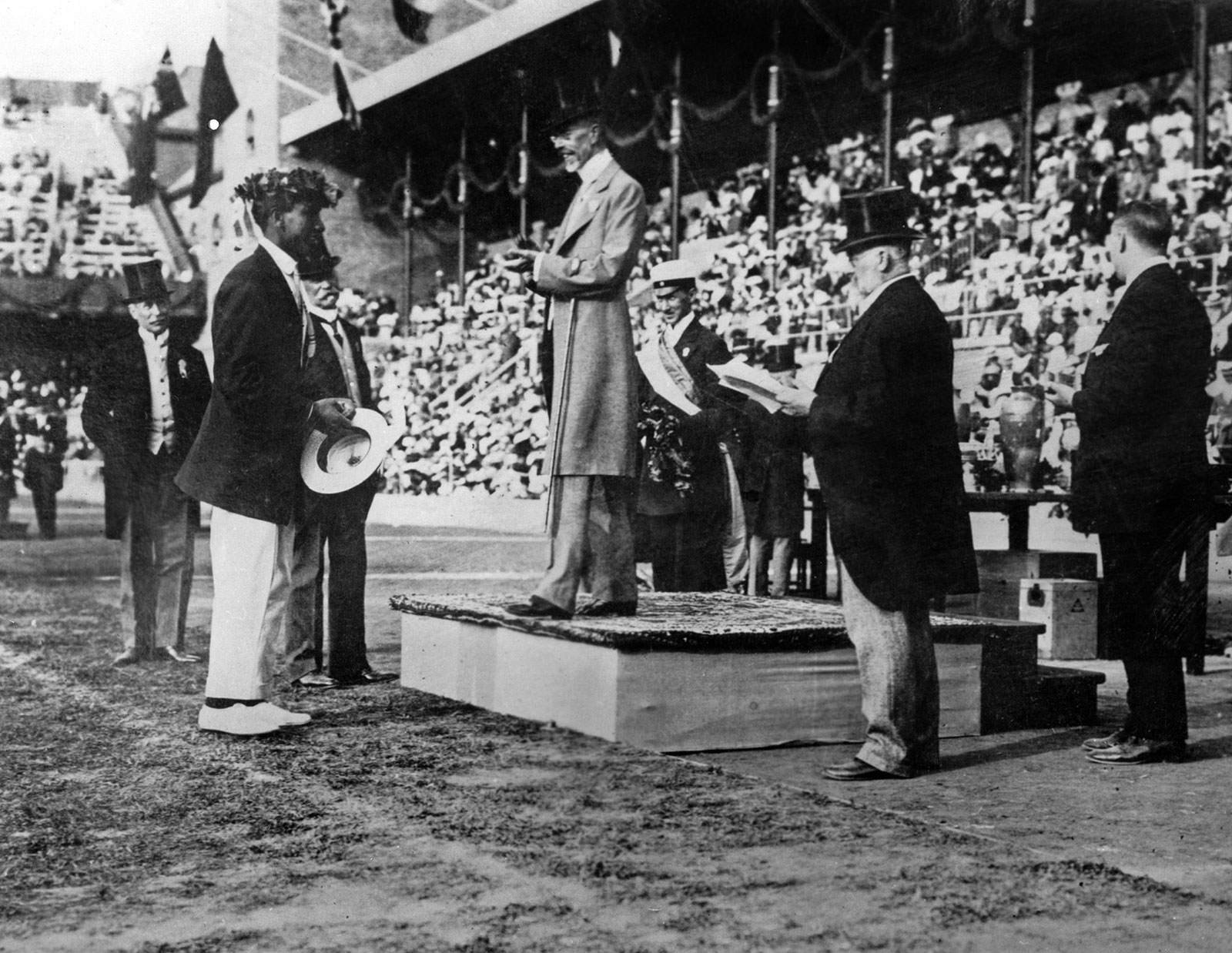 Black and white photograph of Duke Kahanamoku with the King of Sweden during a ceremony in the 1912 Stockholm Olympics.