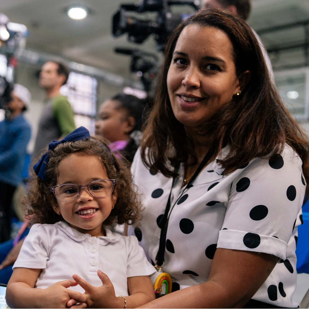 Close-up of a mother (right) sitting with her daughter (left)