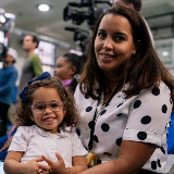 Close-up of a mother (right) sitting with her daughter (left)