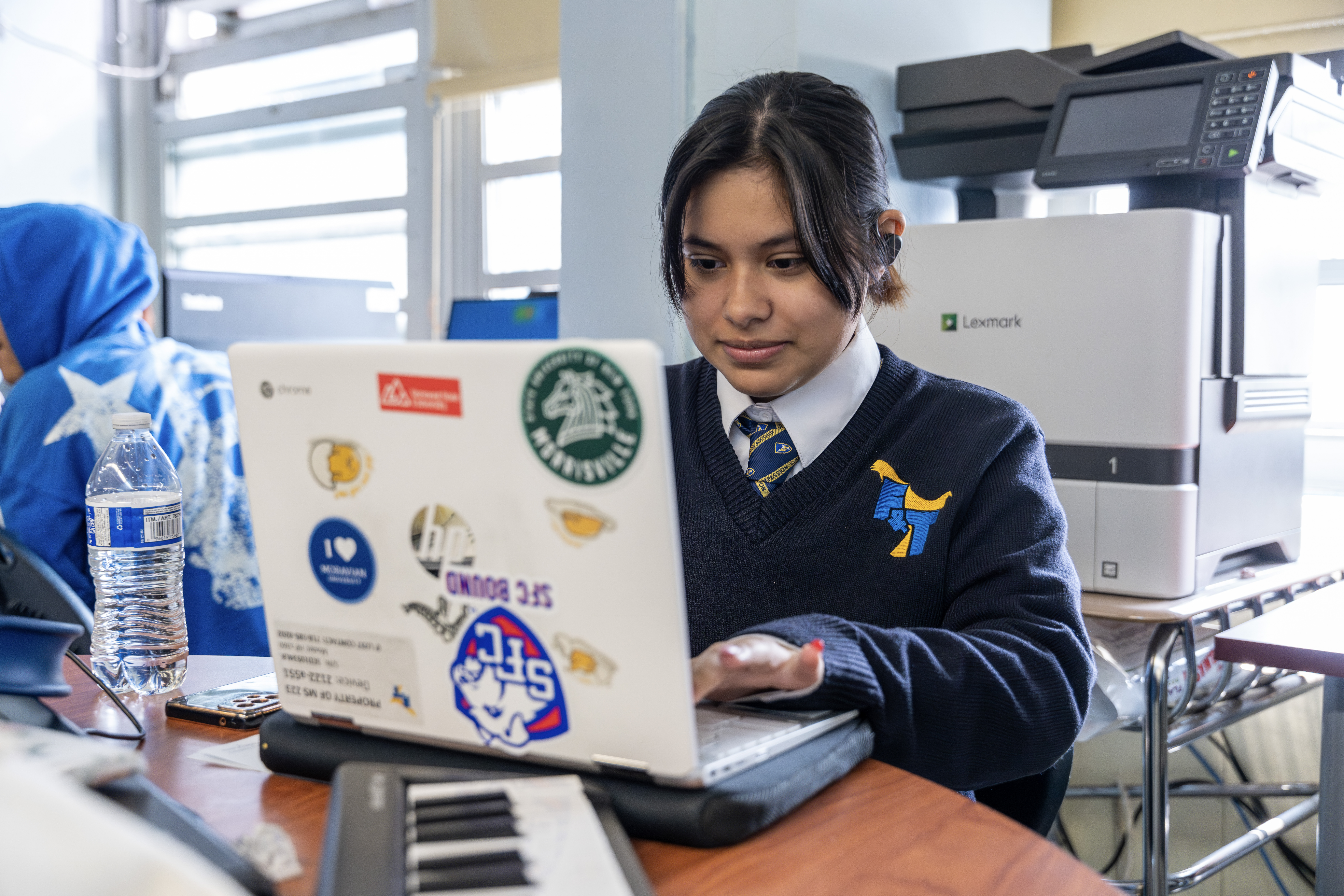 A student using a laptop computer at a desk.