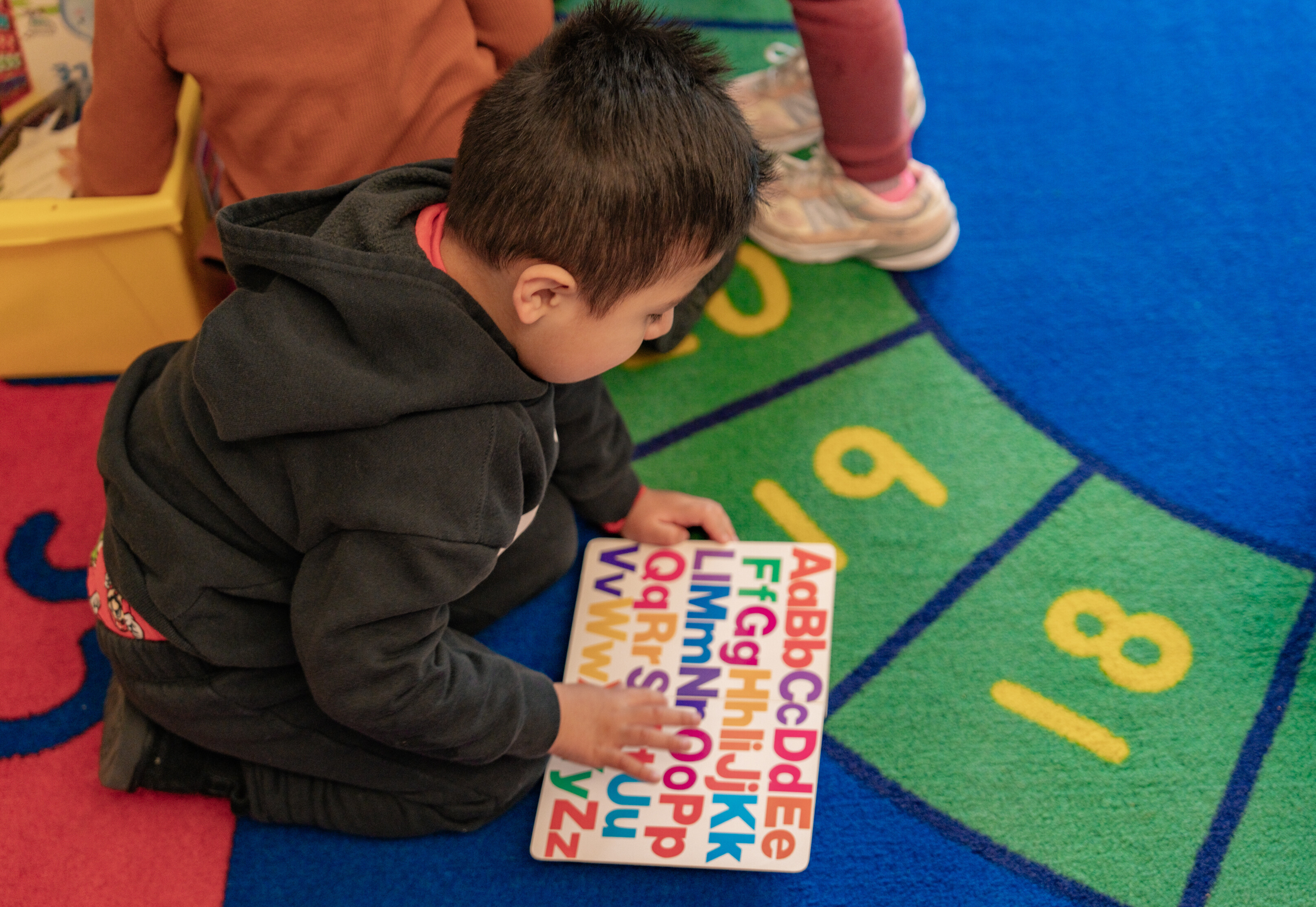 A child reads an alphabet book at school