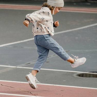 A child jumping in their schoolyard