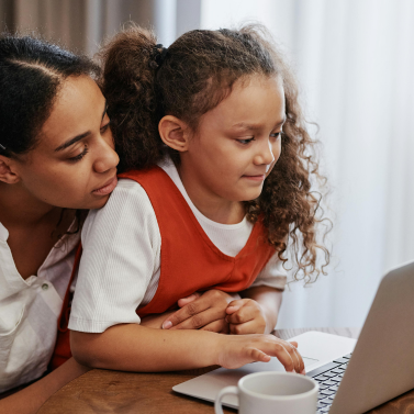 An adult and child using a laptop