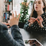 An image of two people communicating using sign language