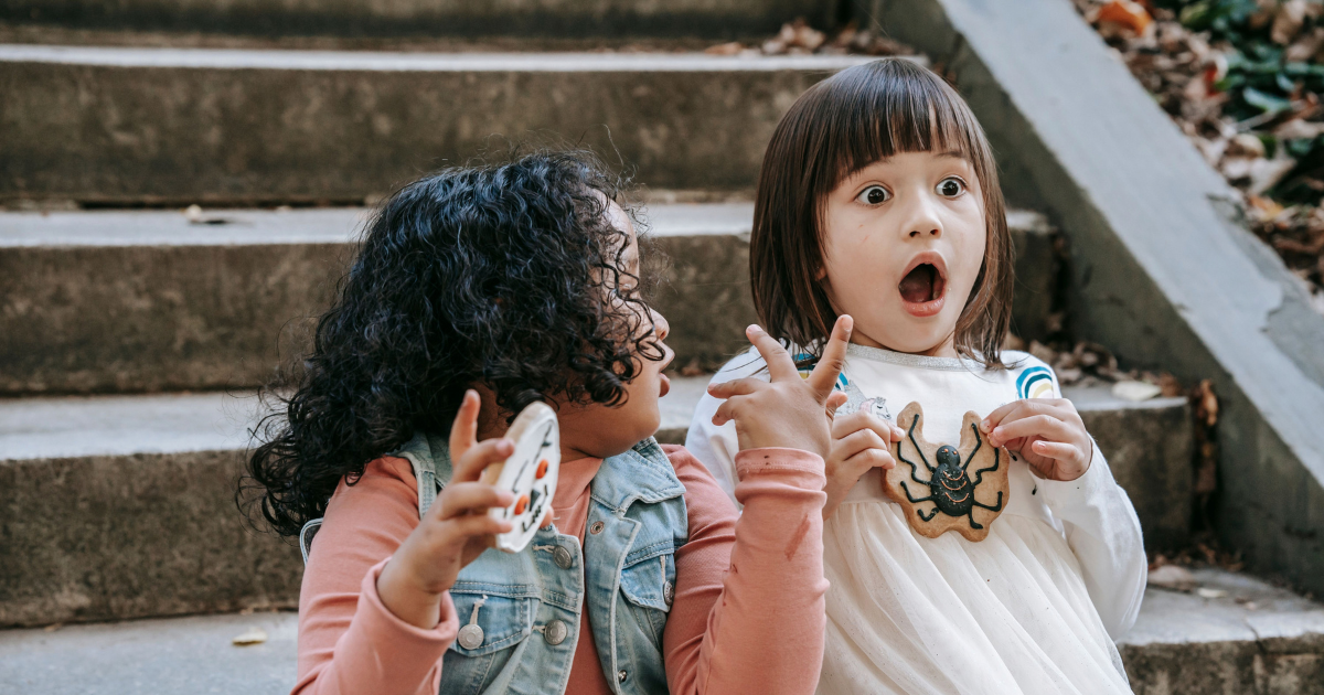Two children with Halloween treats making scared faces
