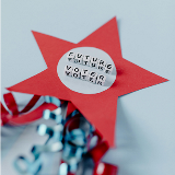 Close-up of a crafted red star featuring glued-on block letters that spell out "Future Voter."