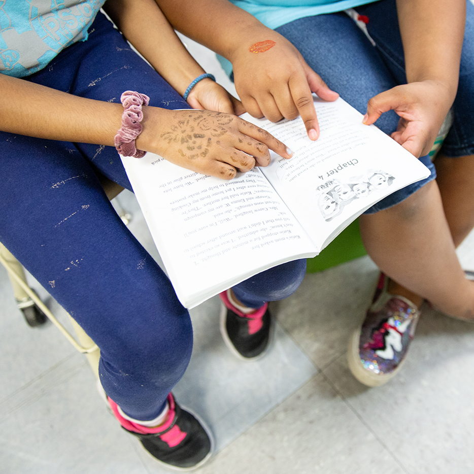 Two students reading a book together