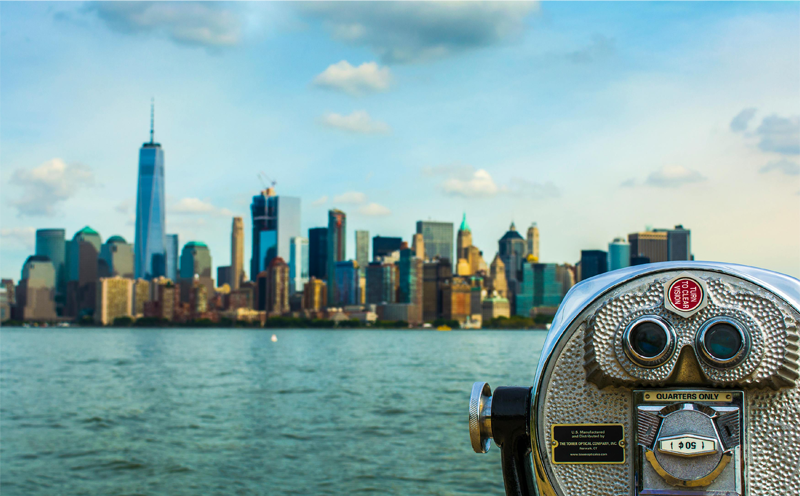 Close-up of a coin-operated set of binoculars facing the NYC skyline.