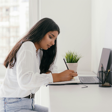 Side view of an older teenager writing at a desk