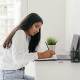Side view of an older teenager writing at a desk
