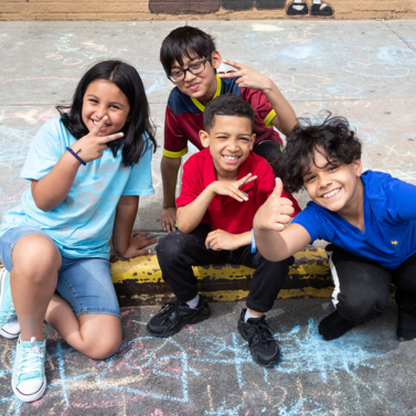 Students play outside their school with chalk