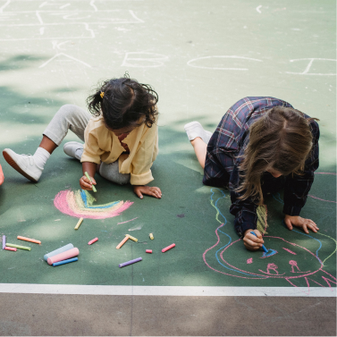 Students drawing with chalk in their school yard