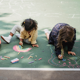 Students drawing with chalk in their school yard