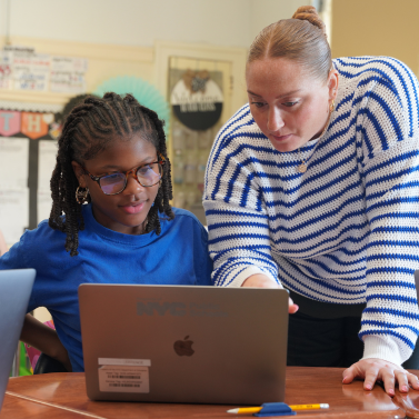 Teacher and student looking at a laptop