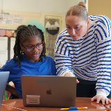 Teacher and student looking at a laptop