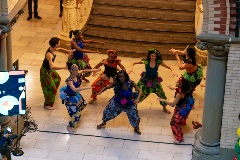 A group of student dancers dressed in colorful dance outfits performing.