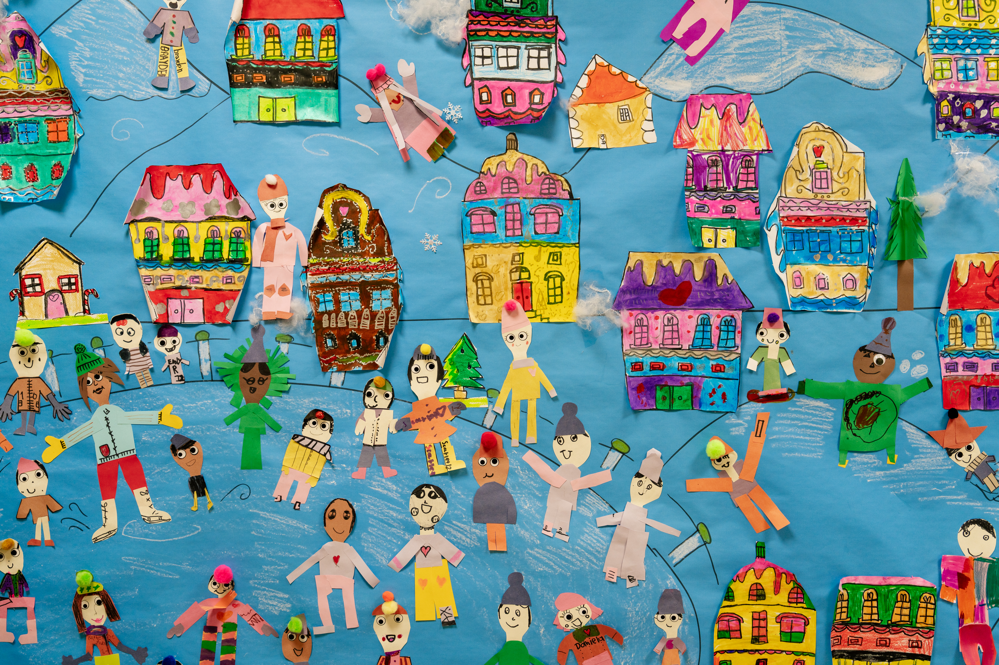 A classroom bulletin board that features student-made, snow-themed decorations.