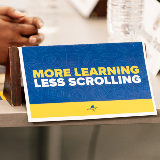 This is a close-up of a pamphlet cover that reads, "More Learning Less Scrolling."