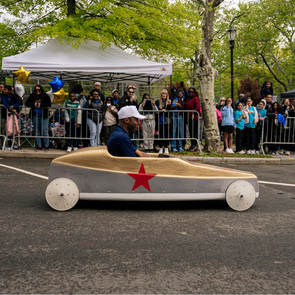 Chancellor Samuels riding in a soapbox car