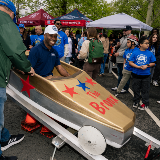 Chancellor Samuels smiling after settling into a gold soap box car