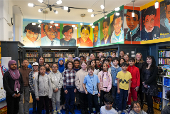 Chancellor Melissa Aviles-Ramos standing along an entire class of X036 students at the X036 library.