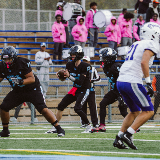 Eagle Academy quarterback (center, #13) scanning field looking for someone to throw the football towards.