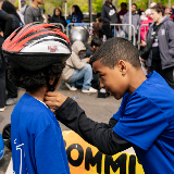 Student helping another student put on a helmet