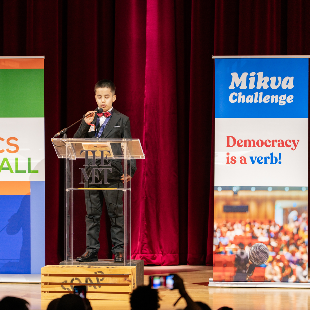 Suited Student at Podium (SoapboxNYC 2026)