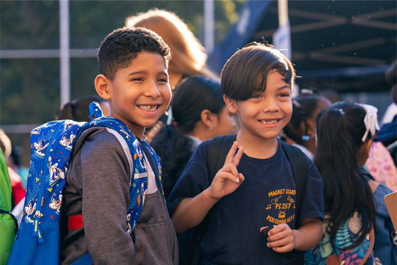 Two male, pre-adolescents, with one of them (right) holding up a 'peace' sign.