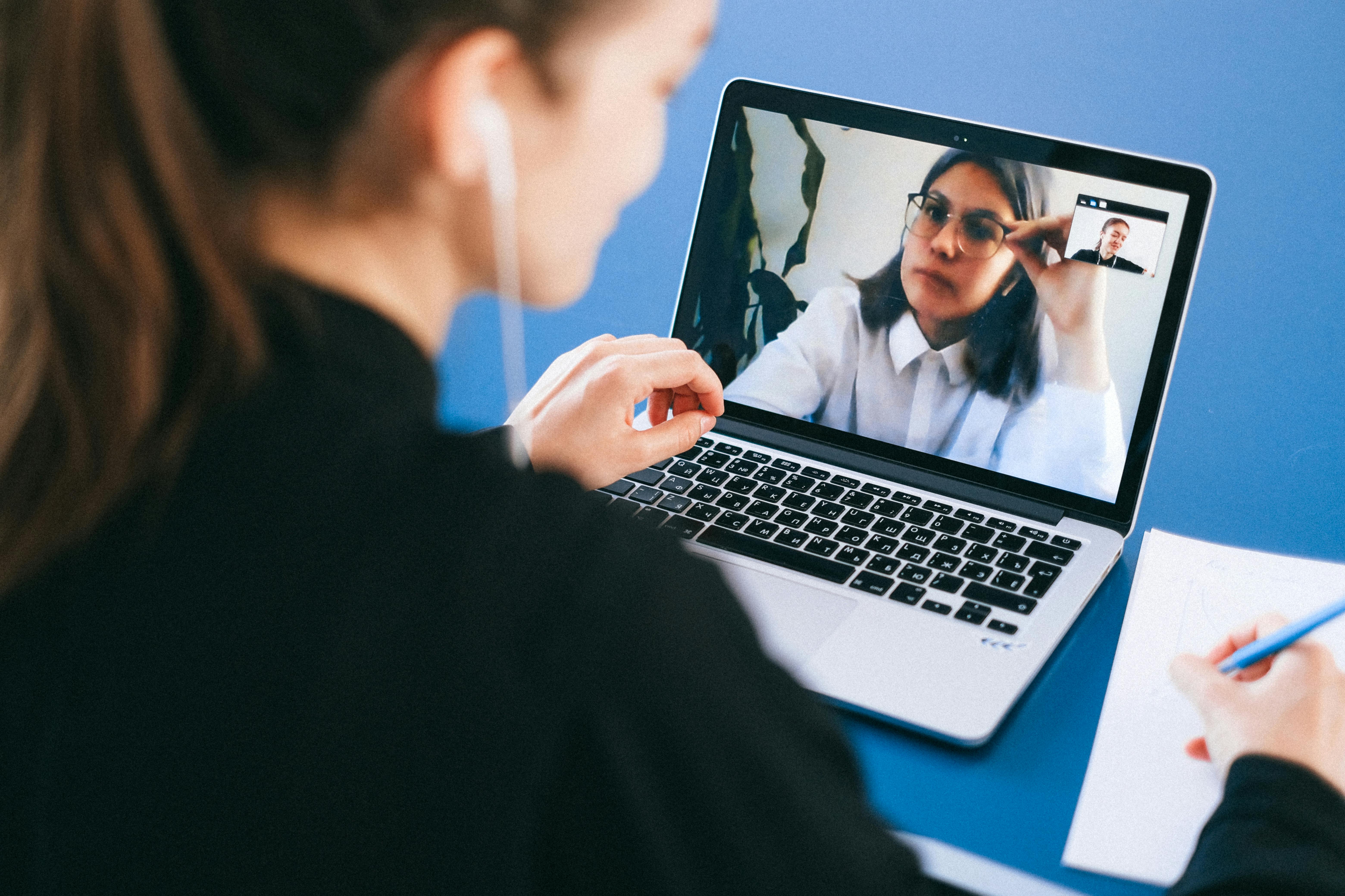 Two people on a video call using a laptop