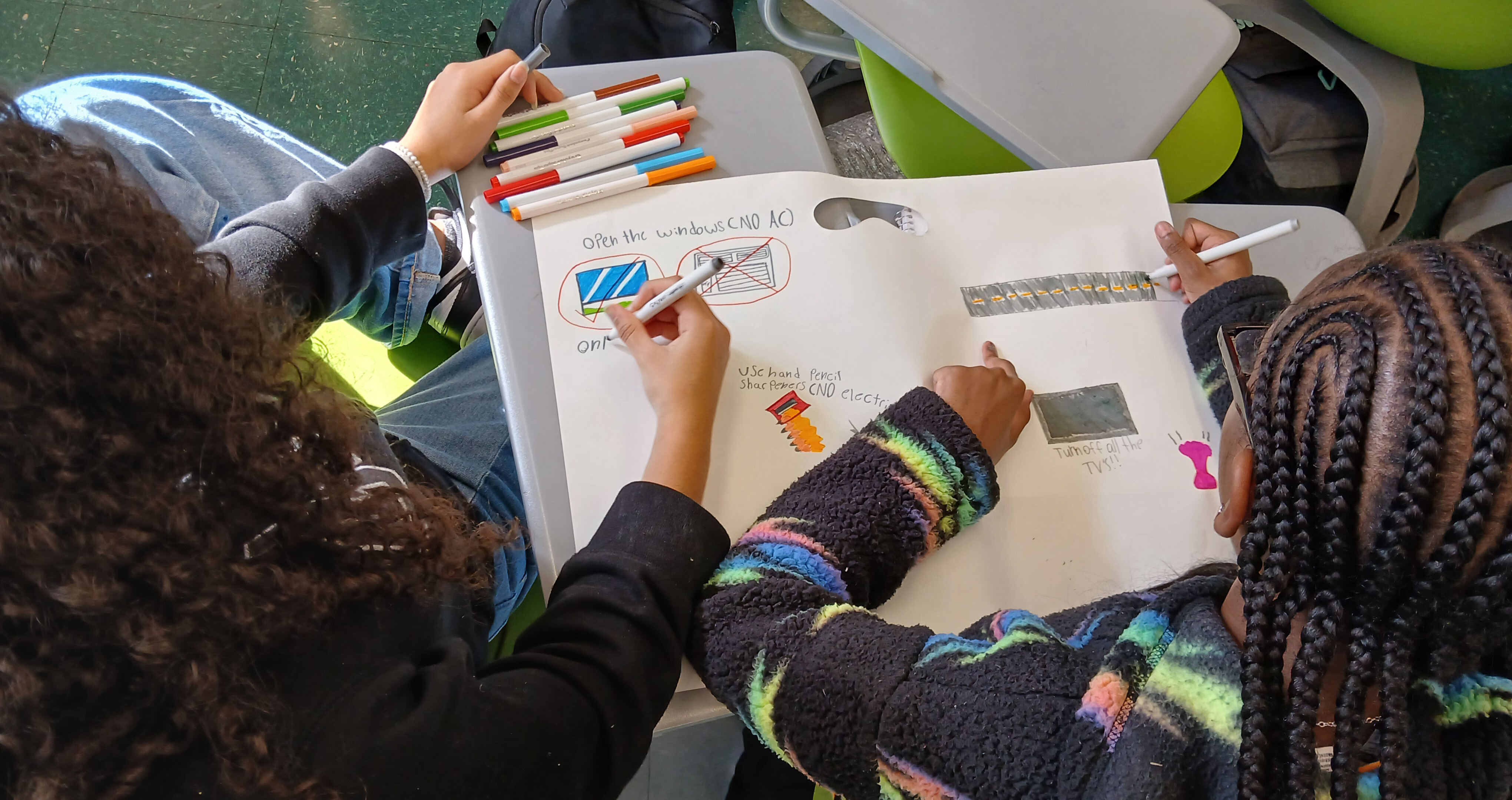 Students write down in their notebook different ways to save energy.